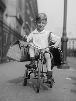 Sidewalk Prints: Youngster rides his tricycle on the sidewalks of New York City